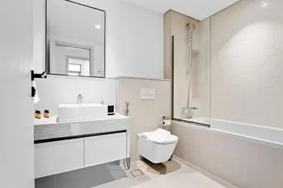 a white bathroom with a sink and a toilet at Family Friendly 2BDR With Sea & City View in Dubai