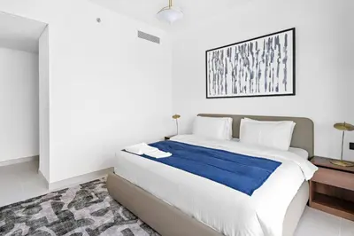 a bedroom with a large bed with a blue blanket at Family Friendly 2BDR With Sea & City View in Dubai