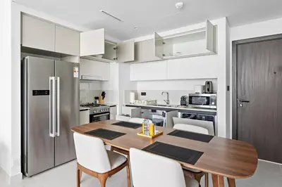 a kitchen with a wooden table and white cabinets at Family Friendly 2BDR With Sea & City View in Dubai