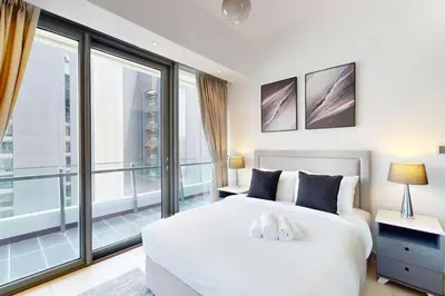 a bedroom with a white bed and a large window at Silverene Tower B - Bright Two Bedroom in Dubai