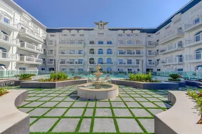 a large building with a fountain in front of it at Studio Apartment in Vincitore Palacio Arjan in Dubai
