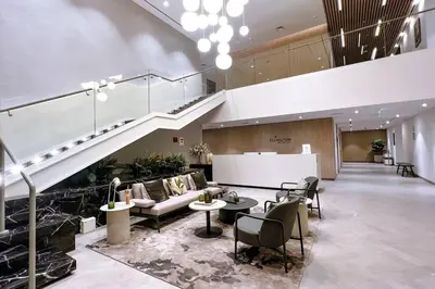 a lobby with a staircase and a couch and chairs at Brand New 1 Bedroom Apartment JVC in Dubai