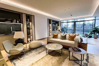 a living room with a couch and a tv at Brand New 1 Bedroom Apartment JVC in Dubai