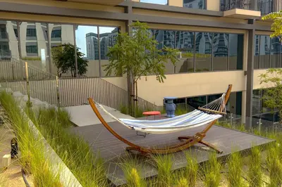 a hammock sitting in front of a building at Brand New Apartment in Socio Tower Dubai Hills in Dubai