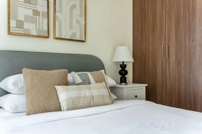a bedroom with a white bed with pillows and a lamp at GuestReady - Luxury haven in JLT in Dubai