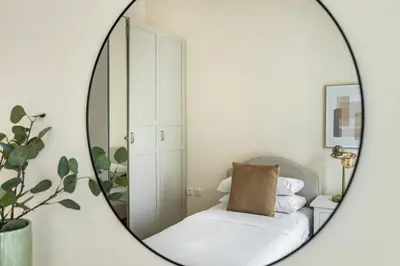 a mirror in a room with a chair with a pillow at GuestReady - Luxury haven in JLT in Dubai