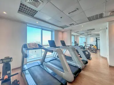 a gym with treadmills and ellipticals in a building at GuestReady - Luxury haven in JLT in Dubai