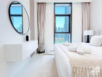 a white bedroom with two beds and a mirror at Luxury Burj Crown 4bedroom Balcony & Downtown View in Dubai