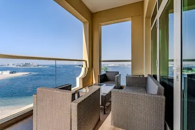 a balcony with chairs and a view of the ocean at Al Hatimi, Shoreline Apartments, Palm Jumeirah, Dubai in Dubai