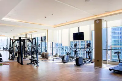 a gym with treadmills and weights in a building at Vacay Lettings - Waves Grande - Sobha Hartland in Dubai