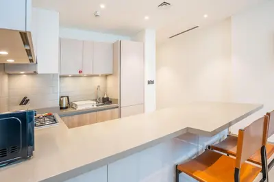 a kitchen with white cabinets and a counter top at Vacay Lettings - Waves Grande - Sobha Hartland in Dubai