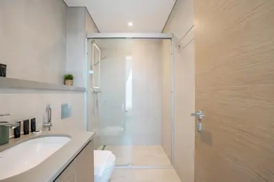 a bathroom with a shower and a sink and a toilet at Vacay Lettings - Waves Grande - Sobha Hartland in Dubai