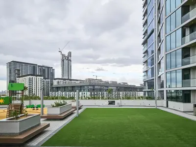 a green lawn on the roof of a building at Vacay Lettings - Waves Grande - Sobha Hartland in Dubai