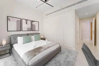 a white bedroom with a large bed and two chairs at Beachfront Luxury Living at La Vie Residence JBR in Dubai