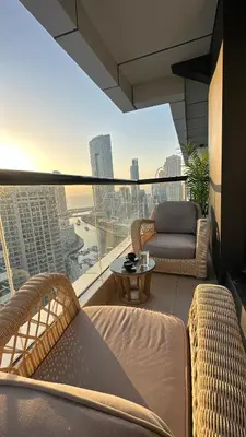a balcony with chairs and a table on a building at Modern 1BR Apartment in Dubai Marina with sea view in Dubai
