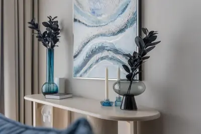 a table with two blue vases and a painting at Clever Guest 021 Condor Marina Star in Dubai