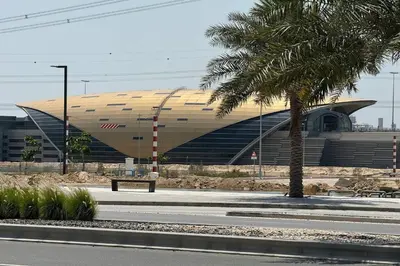 a building with a palm tree and a bench in front of it at Comfortable 2BD apartment next to metro & mall in Dubai