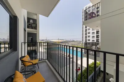 an apartment balcony with a view of a swimming pool at Comfortable 2BD apartment next to metro & mall in Dubai