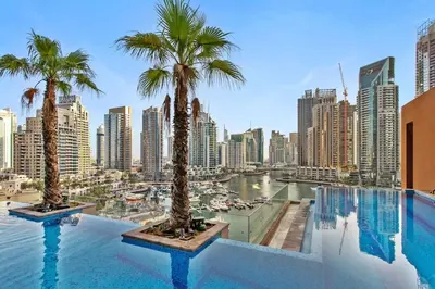 a swimming pool with palm trees and a city at Marina Gate - Stunning 56 Floor Full Sea Views in Dubai