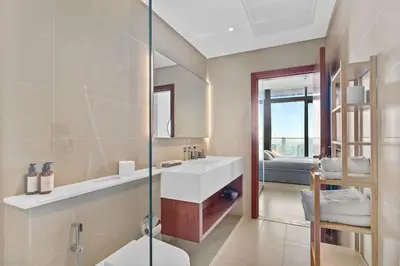 a bathroom with a sink and a glass shower at Marina Gate - Stunning 56 Floor Full Sea Views in Dubai