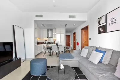a living room with a couch and a dining room at Marina Gate - Stunning 56 Floor Full Sea Views in Dubai
