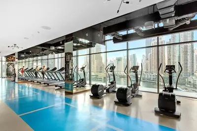 a gym with treadmills and ellipticals in a building at Marina Gate - Stunning 56 Floor Full Sea Views in Dubai