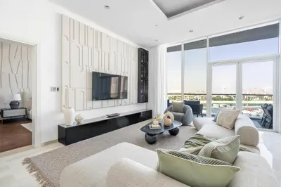 a living room with a couch and a tv at Oceana Luxury 4 BR Apartment with Resort Access and Sea Views by Exclusive Holiday Homes in Dubai
