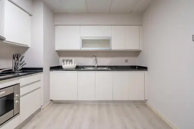 a kitchen with white cabinets and a sink at Oceana Luxury 4 BR Apartment with Resort Access and Sea Views by Exclusive Holiday Homes in Dubai