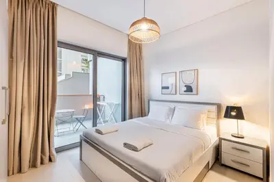 a bedroom with a bed and a large window at Sobha Creek Vistas Cozy 1BDR with balcony in Dubai
