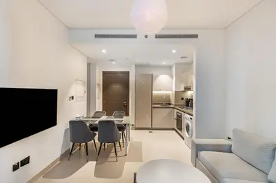 a living room with a table and chairs and a tv at Sobha Creek Vistas Cozy 1BDR with balcony in Dubai