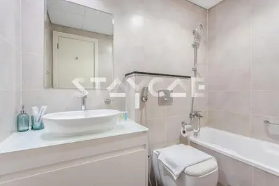 a bathroom with a sink and a tub and a toilet at Staycae Holiday Homes - Carson Towers in Dubai