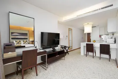 a living room with a desk and a kitchen at Maison Privee - Fabulous Studio with Direct Burj Khalifa Views in Dubai