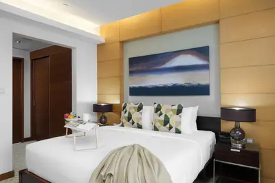 a bedroom with a large white bed with two lamps at Maison Privee - Fabulous Studio with Direct Burj Khalifa Views in Dubai