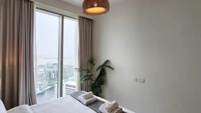 a bedroom with a bed and a large window at Chic New 2BR Dubai Creek Gate by Tanami Holiday Homes in Dubai