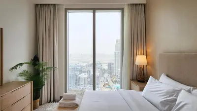 a bedroom with a bed and a large window at Chic New 2BR Dubai Creek Gate by Tanami Holiday Homes in Dubai