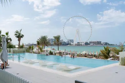 a swimming pool with a ferris wheel in the background at Ahlan HH - Luxurious 1BR Suite at La Vie - Free Private Beach Access in Dubai