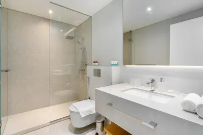 a bathroom with a toilet and a sink and a shower at Ahlan HH - Luxurious 1BR Suite at La Vie - Free Private Beach Access in Dubai
