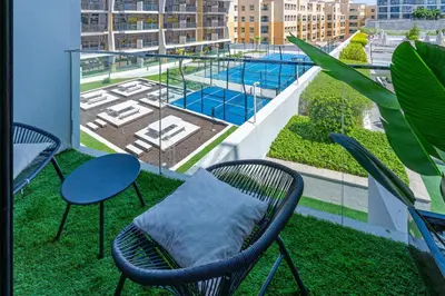 a balcony with a table and chairs and a pool at Elegant Studio Stay I Pool, Gym & Parking in Dubai