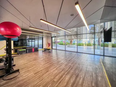 an empty office with a wooden floor and large windows at GuestReady - Contemporary studio in Business Bay in Dubai