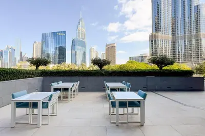 a patio with tables and chairs and a city skyline at GuestReady - Glamorous place near Burj Khalifa in Dubai