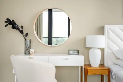 a dressing table with a mirror and a white chair at GuestReady - Above the clouds in Dubai Marina in Dubai