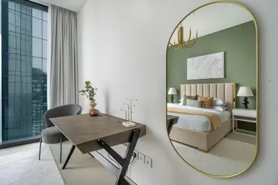 a bedroom with a bed and a mirror at GuestReady - Above the clouds in Dubai Marina in Dubai