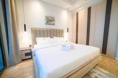 a bedroom with a large bed with white sheets at Luxurious New 1BR Apt Prime Jumeirah Garden City in Dubai