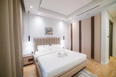 a bedroom with two beds with white sheets at Luxurious New 1BR Apt Prime Jumeirah Garden City in Dubai