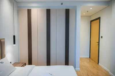 a bedroom with white walls and wooden floors at Luxurious New 1BR Apt Prime Jumeirah Garden City in Dubai