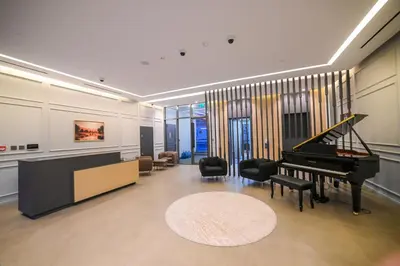 a living room with a grand piano and chairs at Luxurious New 1BR Apt Prime Jumeirah Garden City in Dubai