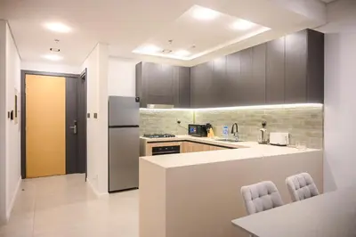 a kitchen with a counter and a refrigerator at Luxurious New 1BR Apt Prime Jumeirah Garden City in Dubai