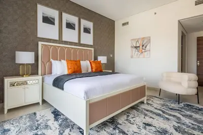 a bedroom with a large bed and a chair at Frank Porter - Eleganz by Danube in Dubai