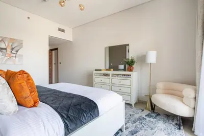 a bedroom with a bed and a dresser and a chair at Frank Porter - Eleganz by Danube in Dubai