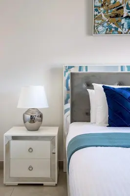 a bedroom with a bed and a nightstand with a lamp at Frank Porter - Eleganz by Danube in Dubai